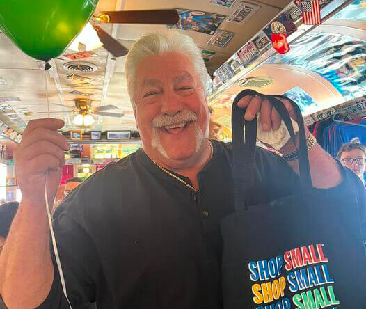 Scott Tranter holding Chamber balloon and Shop Local bag