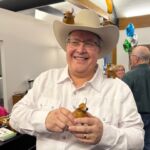 man holding plastic cow