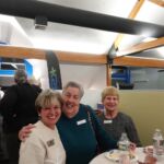 women smiling while seated at a table
