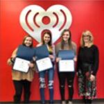 group in front of iheart sign