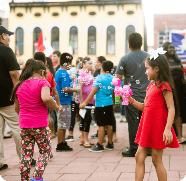 young girls playing with bubble making toys