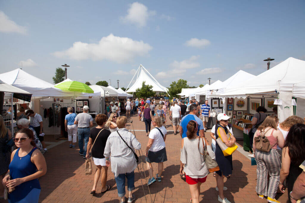 outdoor event crowd walking among vendor booths