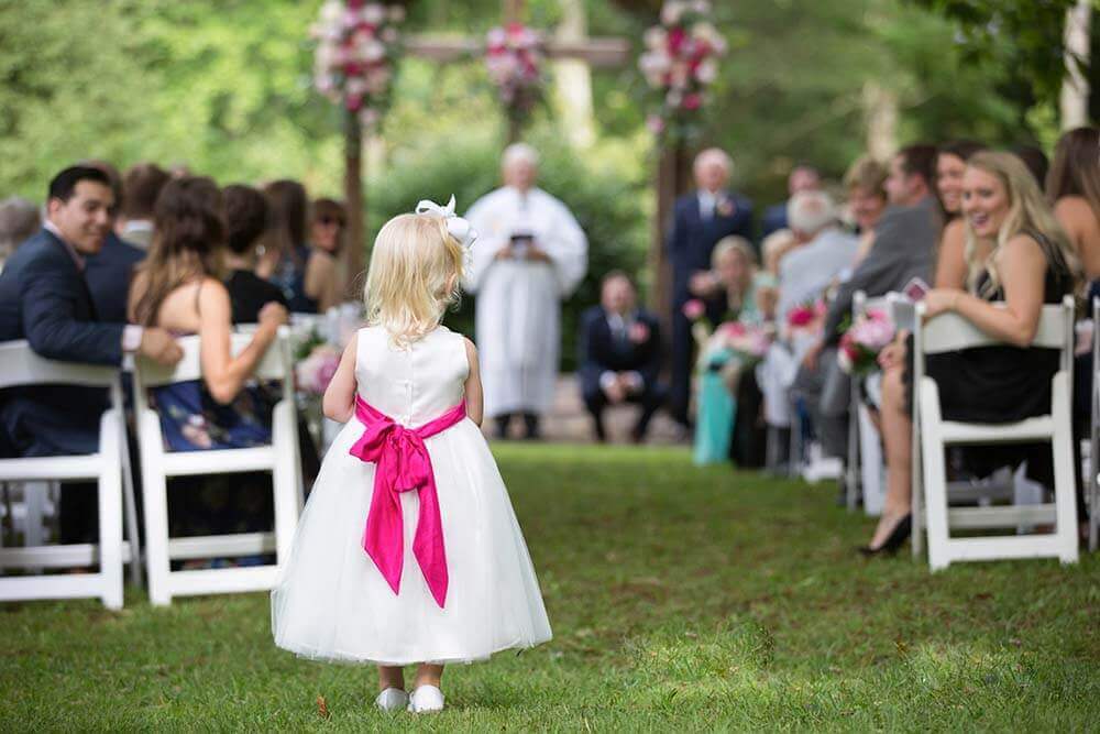wedding guests watching flower girl come down the aisle