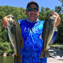 man holding a trout in each hand