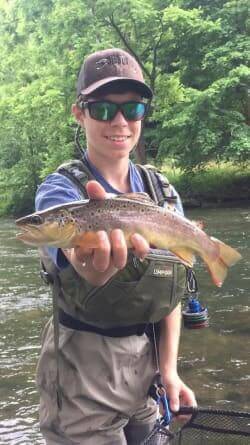 Kid holding up a trout he just caught