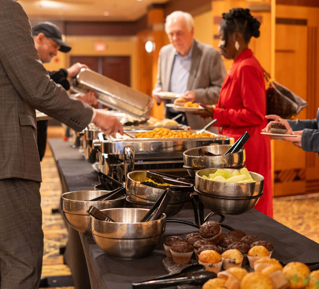 Attendees serve themselves at a buffet during the OktoberFest Business Expo at the Par-A-Dice Hotel & Casino