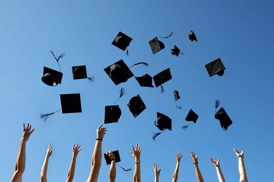 Graduation Caps Thrown in the Air on blue sky