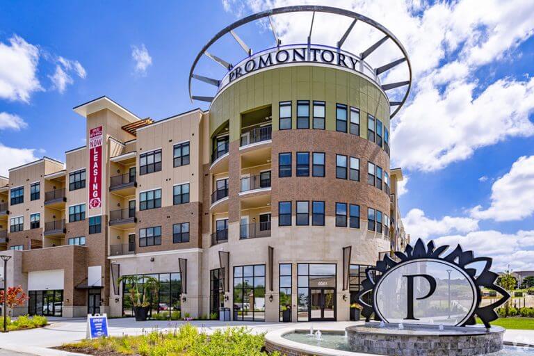 Promontory-768x512 Multi-story downtown retail building with storefront signage and a parking structure