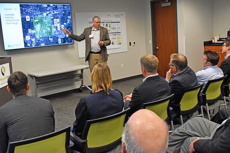 ULI-panel-012-768x512 Man presenting to a group of seated attendees in a modern conference room