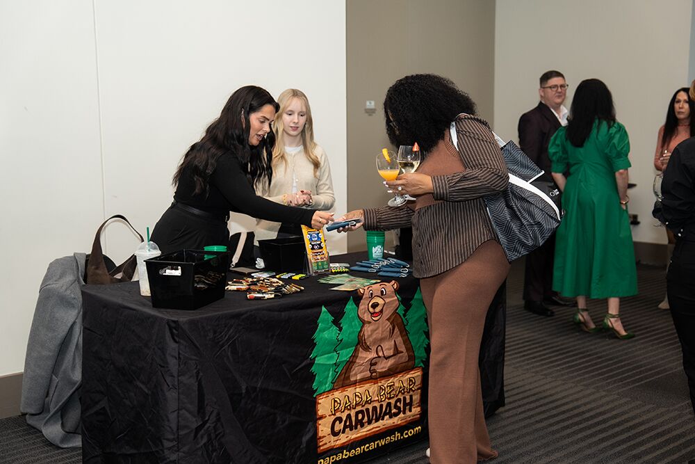 Attendees visiting an exhibitor table at a business expo