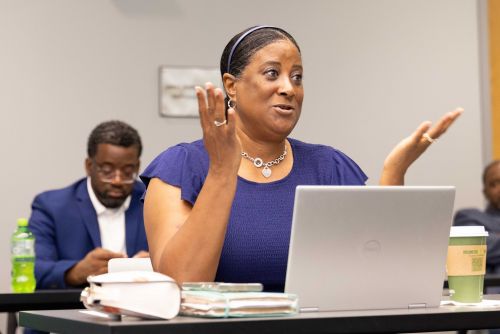 Speaker gesturing while talking at a table during a session
