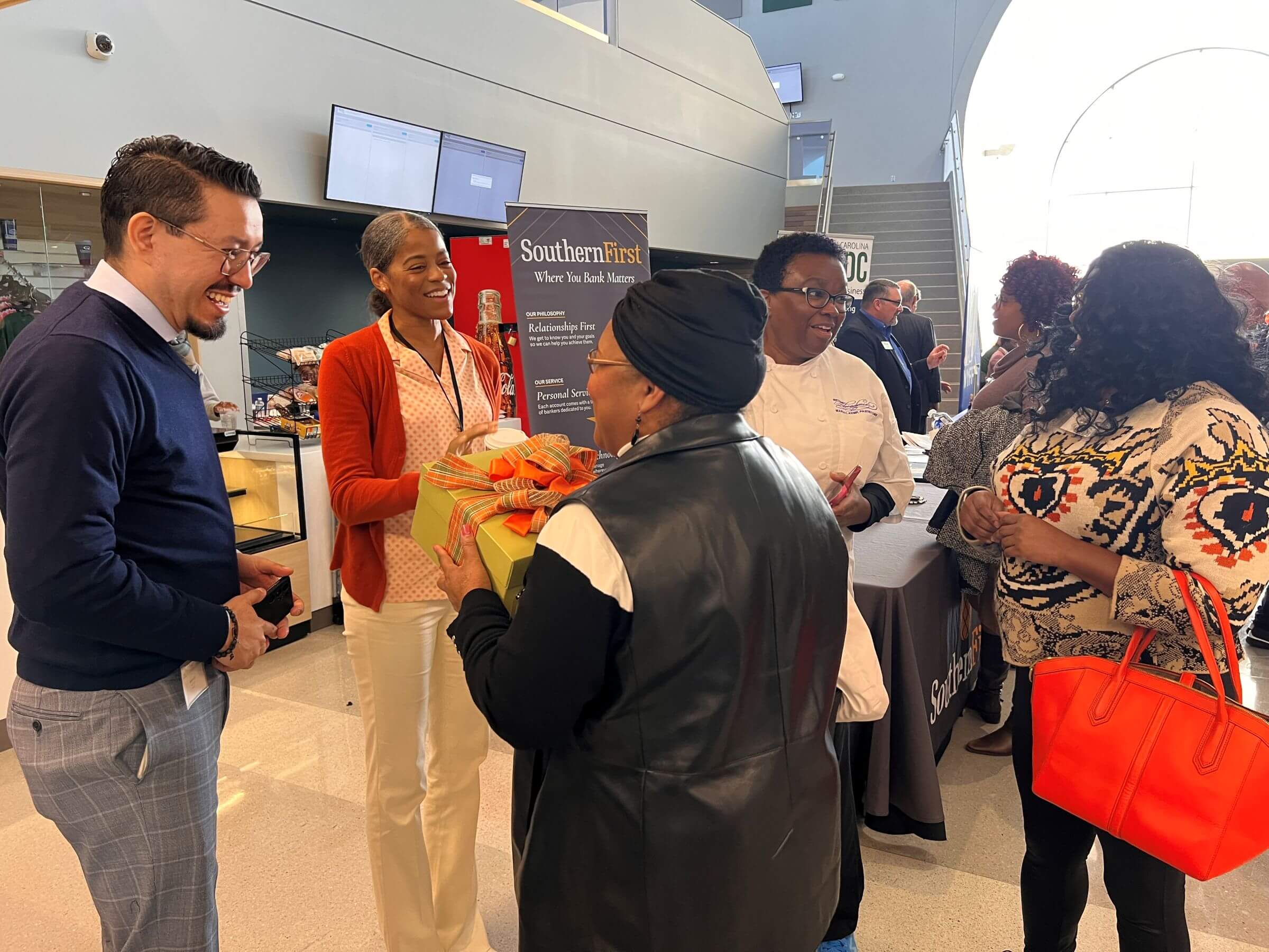Attendees chatting and holding flowers at a networking event