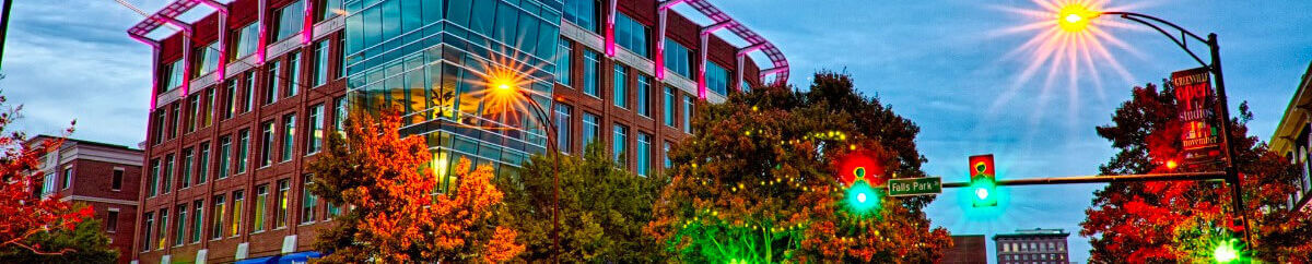 Downtown Greenville street with city lights at dusk