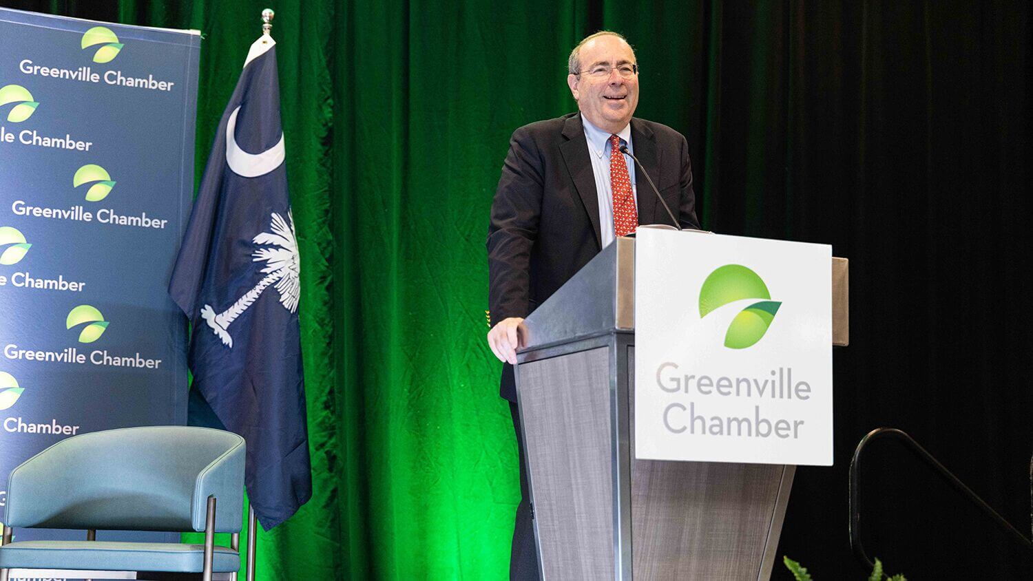 Speaker at a Greenville Chamber podium during the 2026 State of Greenville