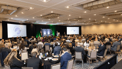 Audience seated at round tables in a ballroom during the 2026 State of Greenville
