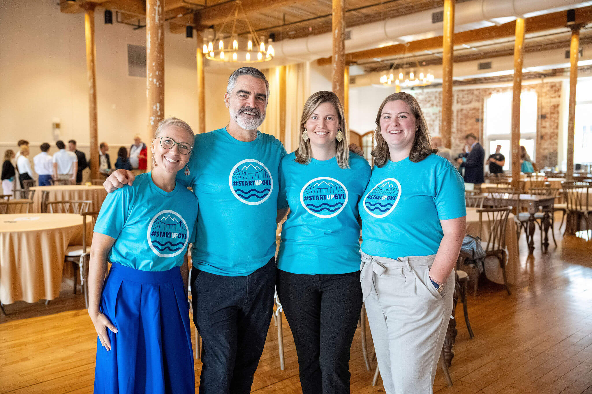 Team in matching blue shirts posing in an event venue
