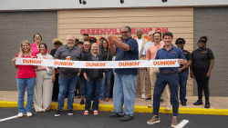 Ribbon cutting celebration outside a Dunkin' location