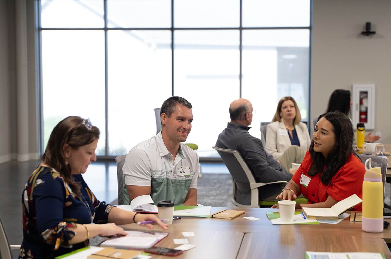Attendees taking notes during a meeting at a conference table