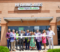 Ribbon cutting outside the Hear Again America hearing aids office at Verdae