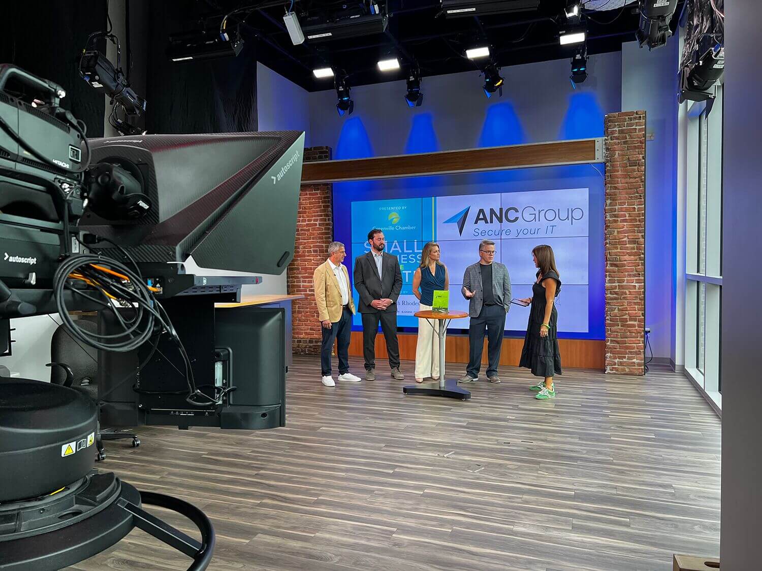 Small Business of the Month honorees on a TV studio set viewed from behind the cameras