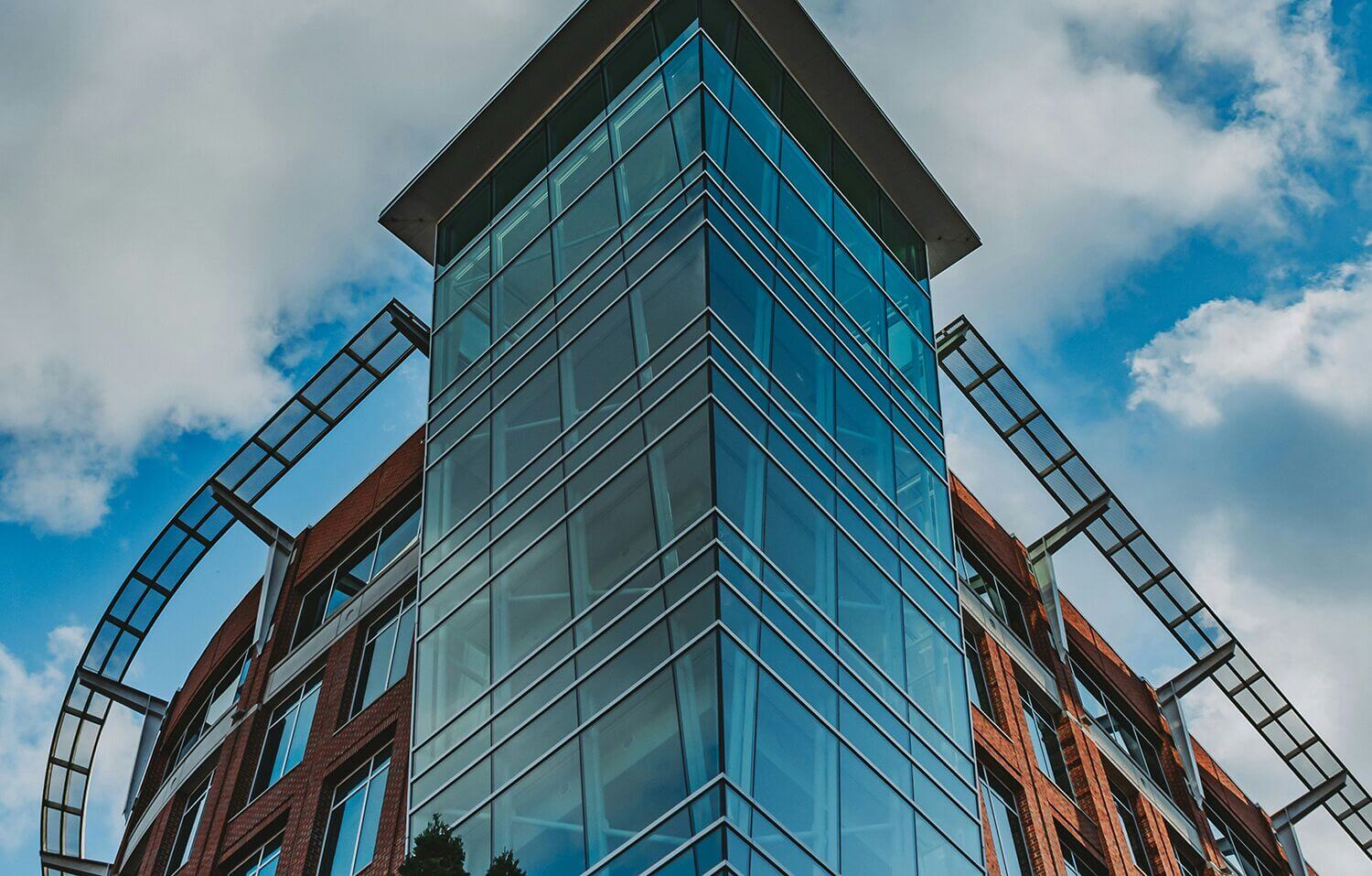 Glass and brick tower against a blue sky in downtown Greenville