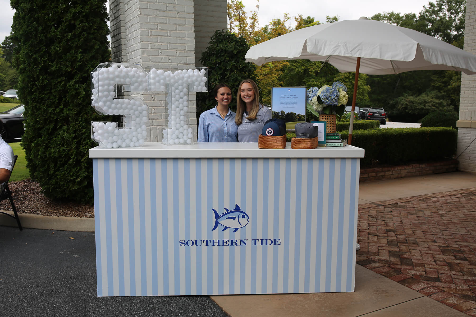 Vendors at a branded outdoor display booth beside large white letters