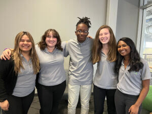 Young professionals in matching gray shirts posing together