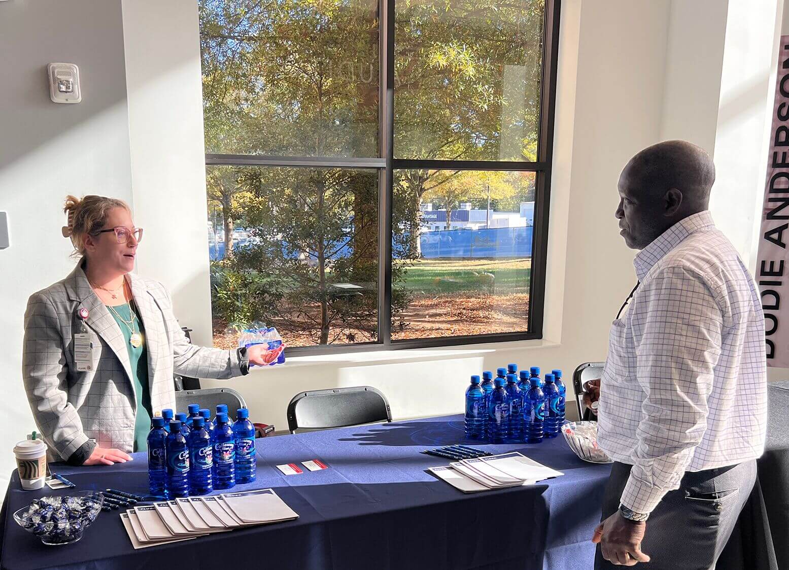 Exhibitor talking with an attendee at a display table