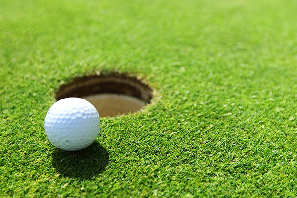 golf ball on lip of cup