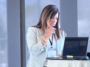woman speaking into microphone in front of group of people