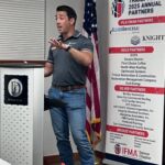 man speaking to group of people at podium