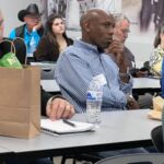 people sitting at tables watching presentation
