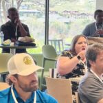 people sitting around tables watching presentation