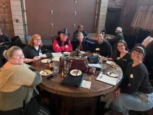 group of people sitting around table eating a meal