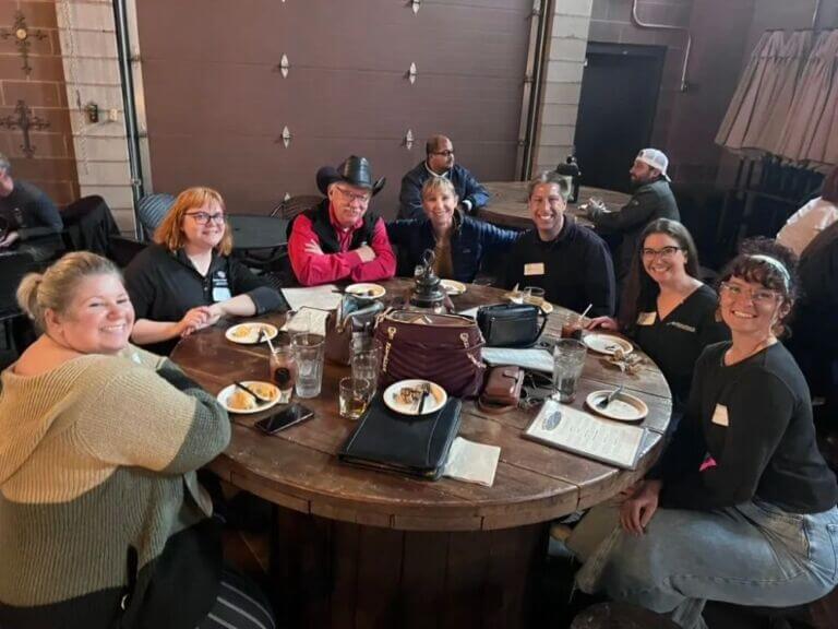group of people sitting around table eating a meal