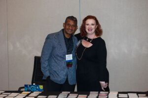 two people standing behind registration desk
