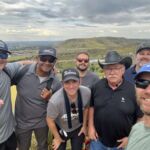 group of men standing with view of foothills in the background
