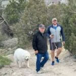 two men and a dog on hiking trail