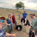 group of people with a dog hiking on trail