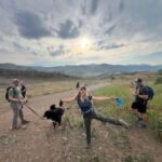 group of people with a dog hiking on trail