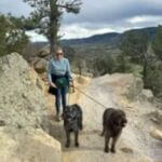 woman with two dogs on hiking trail