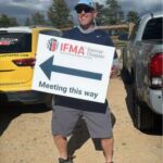 Man holding meeting this way sign