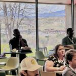 people sitting around tables watching presentation