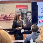 woman speaking in front of people at event
