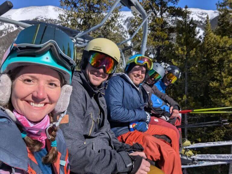 group of five people in ski gear riding chairlift