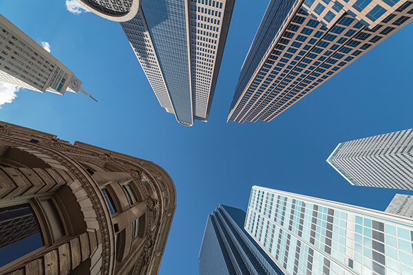 Upward view of skyscrapers against blue sky