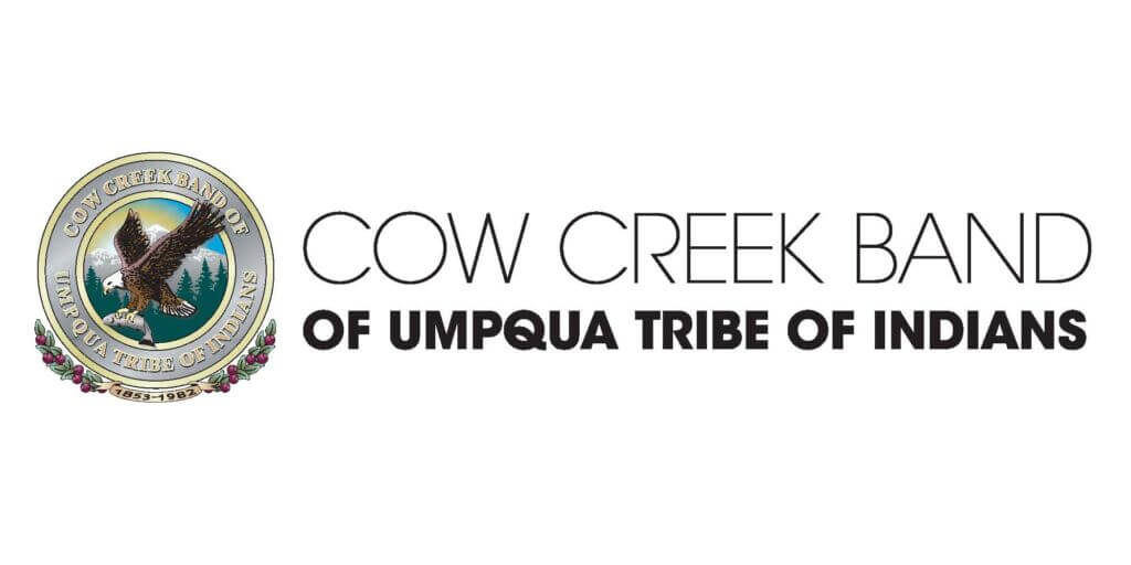 circle image with a bald eagle holding a salmon with the sky and mountains in the b ackground. text around the circle says cowcreek band of umpqua tribe of indians.