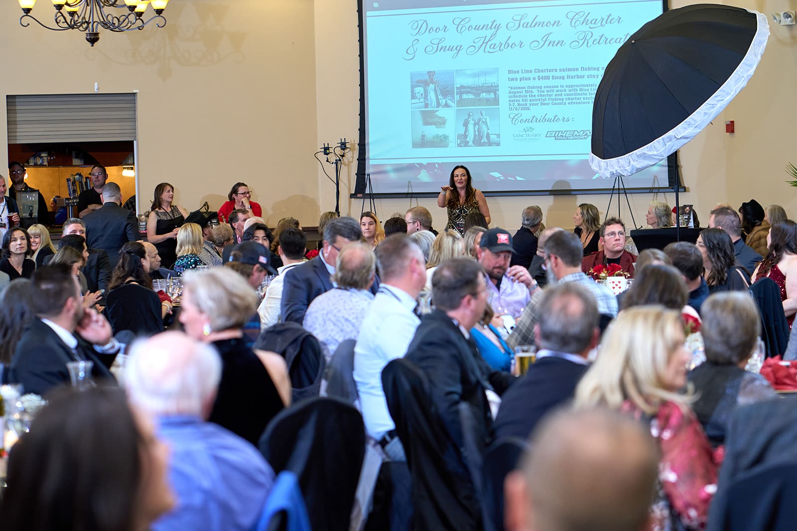 Attendees seated at tables watching a presentation at the chamber casino night gala