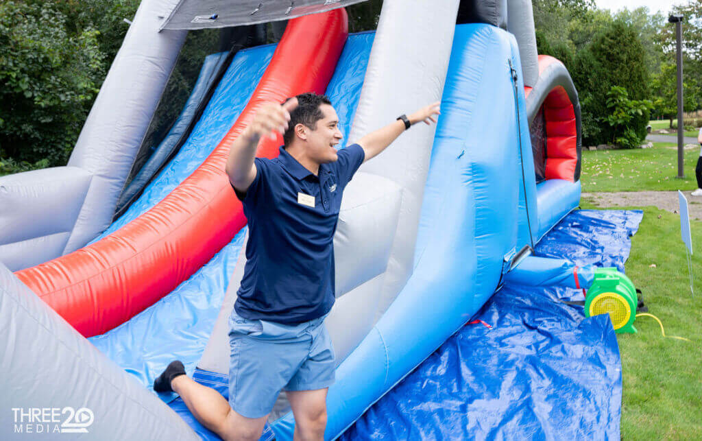 man jumping out of bouncy slide