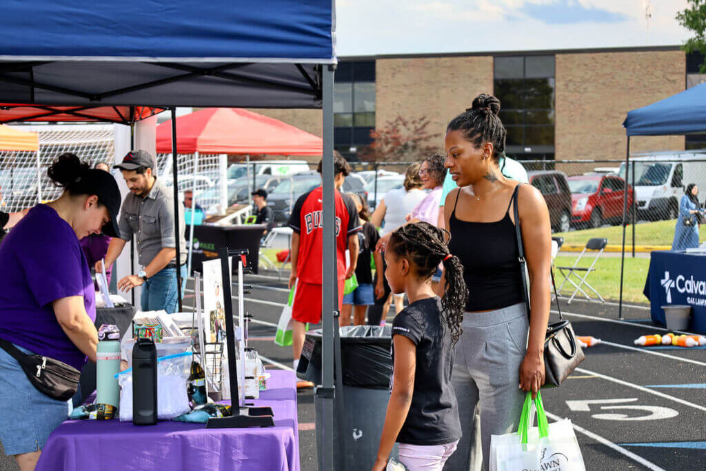 mom and daughter checking out booth Arts & Crafts fair